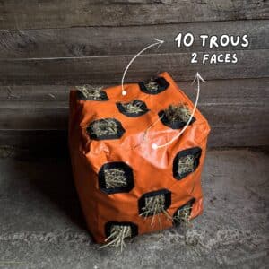 sac à foin Herbi’Box 10 trous avec deux faces trouées, dans une écurie, en toile PVC renforcée. Sac à foin conçu et cousu en France.