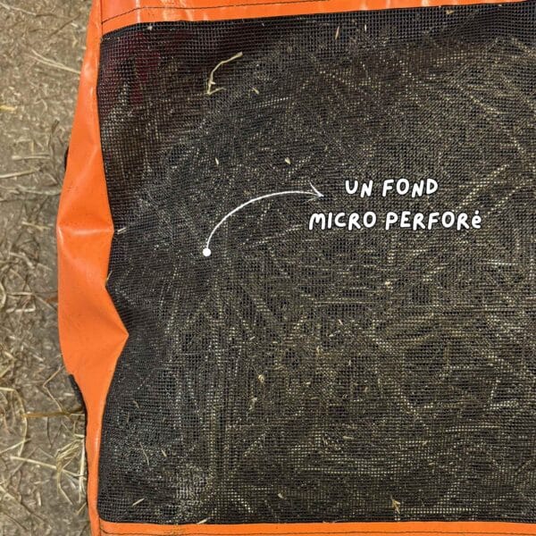 sac à foin Herbi’Box 10 trous avec deux faces trouées, dans une écurie, en toile PVC renforcée. Sac à foin conçu et cousu en France.