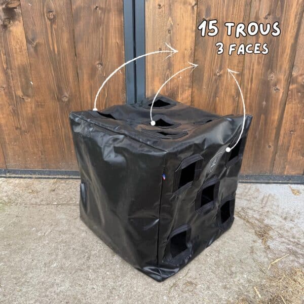 sac à foin Herbi’Box 15 trous avec trois faces trouées, dans une écurie, en toile PVC renforcée. Sac à foin conçu et cousu en France.