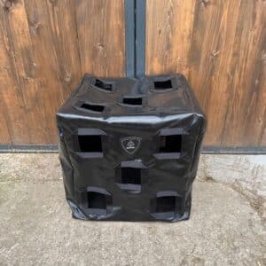 sac à foin Herbi’Box 15 trous avec trois faces trouées, dans une écurie, en toile PVC renforcée. Sac à foin conçu et cousu en France.